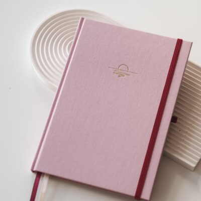 Planner B5 Dolce Vita z różową twardą okładką i złoconym motywem zachodu słońca